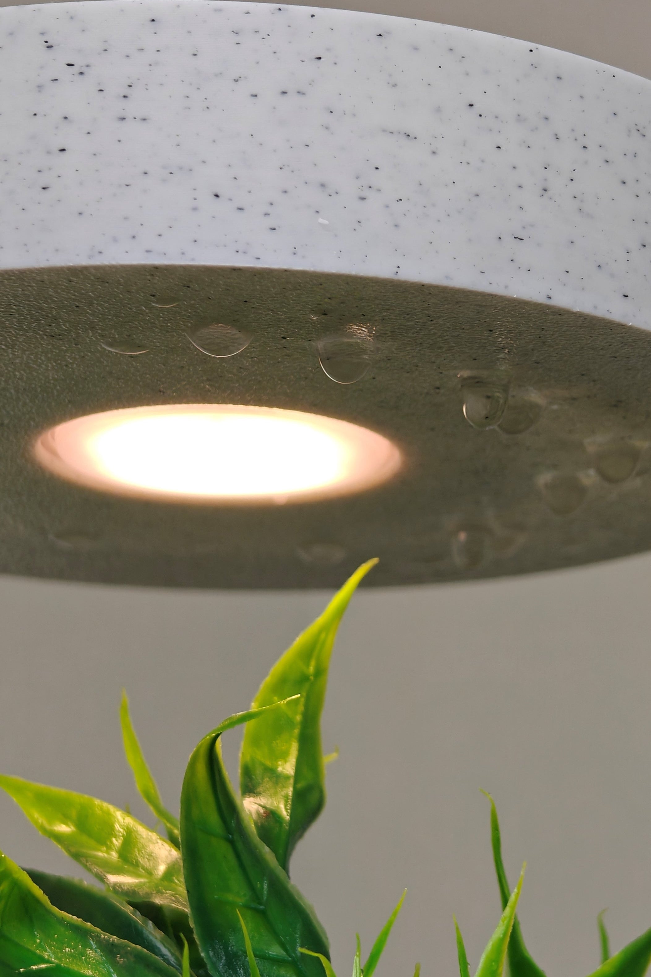 Aura Planter with soft-glow LED halo on a nightstand, creating a serene ambiance in a bedroom setting